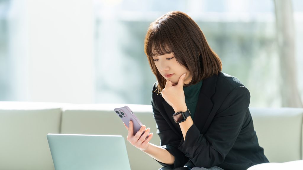 スマートフォンを操作しながら複雑なイベント登録フォームや決済に悩むビジネスパーソン